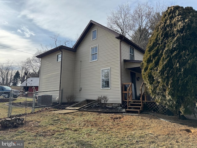 rear view of house with a porch, fence, and a lawn