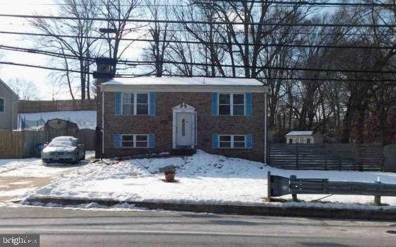 raised ranch with driveway and fence