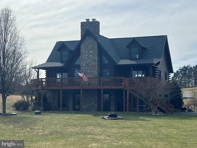 rear view of house with log siding, a lawn, an outdoor fire pit, and stairs