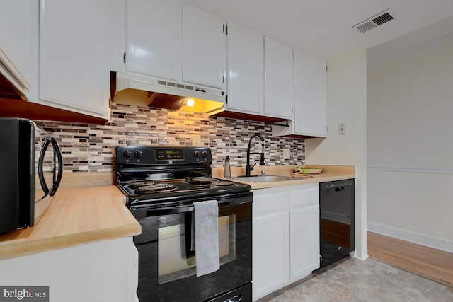 kitchen featuring light countertops, visible vents, white cabinets, under cabinet range hood, and black appliances