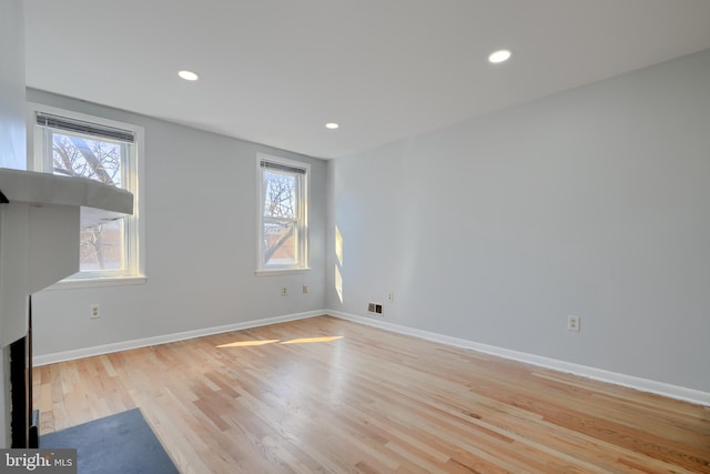 unfurnished living room featuring light wood-style floors, recessed lighting, visible vents, and baseboards