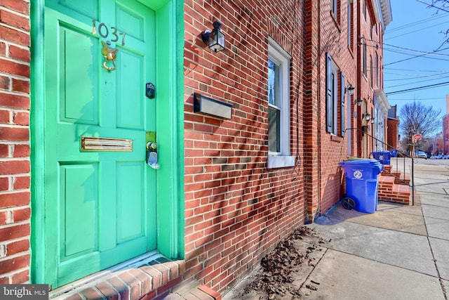 view of exterior entry with brick siding