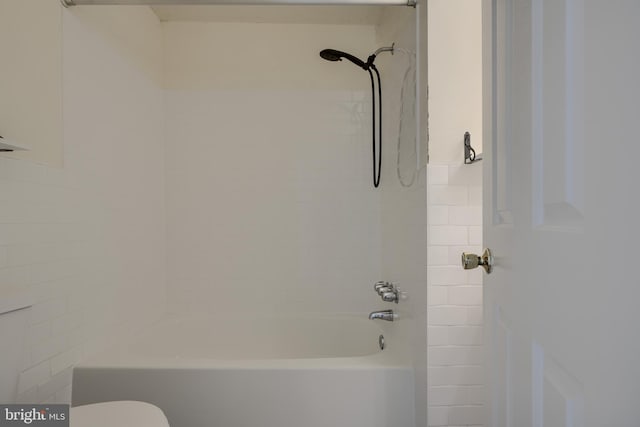 bathroom featuring shower / washtub combination and toilet