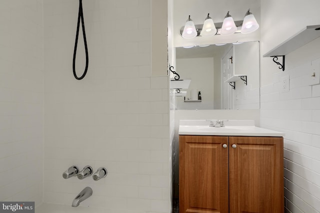 full bathroom featuring tile walls, vanity, and bathing tub / shower combination