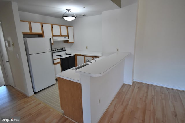 kitchen with range with electric cooktop, freestanding refrigerator, a peninsula, light countertops, and under cabinet range hood