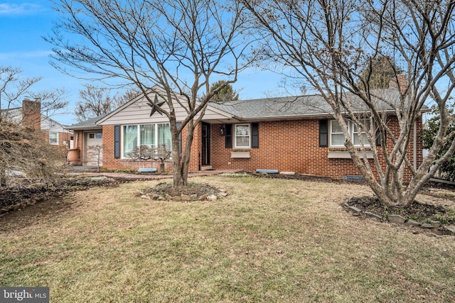 single story home featuring brick siding, an attached garage, a shingled roof, and a front yard