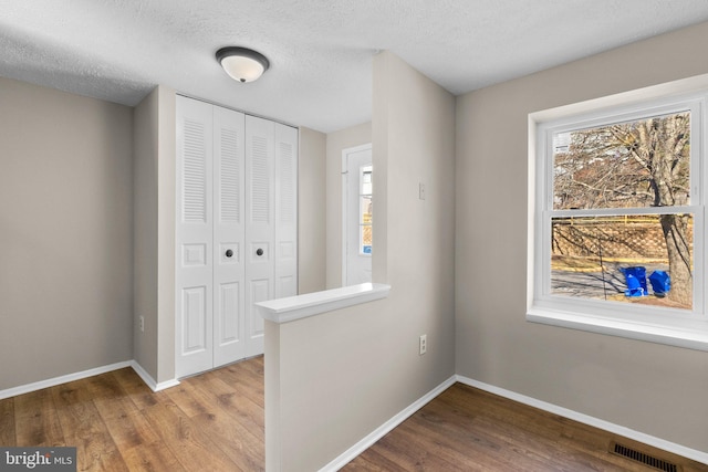 interior space featuring a closet, visible vents, multiple windows, and baseboards