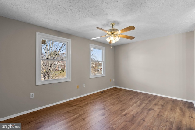 unfurnished room with baseboards, a textured ceiling, wood finished floors, and a ceiling fan