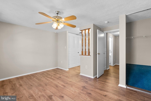 unfurnished bedroom featuring wood finished floors, baseboards, and a textured ceiling