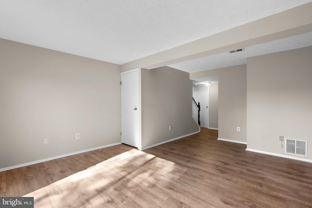 interior space with visible vents, stairs, and wood finished floors