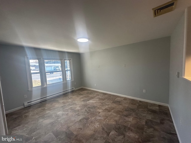 spare room with a baseboard heating unit, visible vents, and baseboards