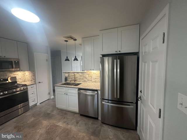 kitchen featuring stainless steel appliances, a sink, visible vents, white cabinetry, and tasteful backsplash