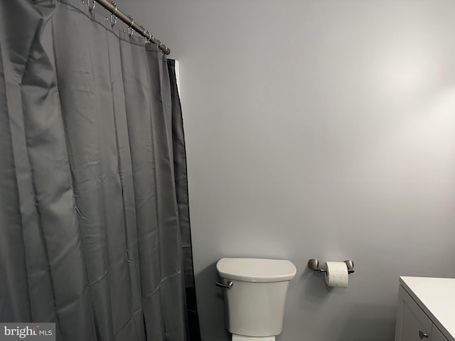 bathroom with toilet, a shower with curtain, and vanity