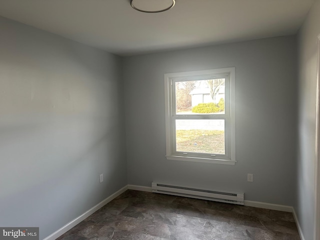 spare room with a baseboard heating unit and baseboards