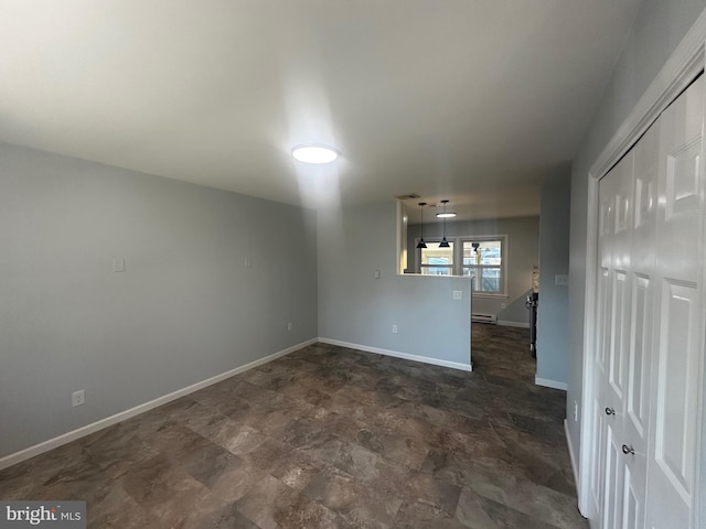 empty room featuring a baseboard radiator and baseboards