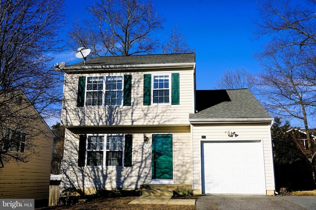 colonial inspired home featuring a garage, driveway, and roof with shingles