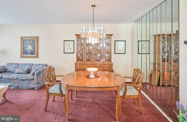 carpeted dining area featuring a notable chandelier