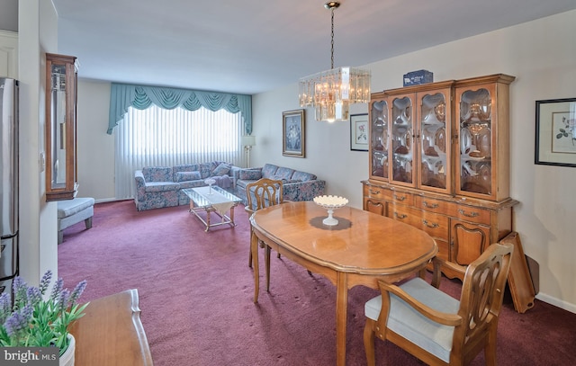 dining area featuring baseboards, dark carpet, and a notable chandelier