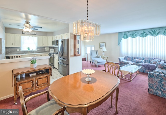 dining room featuring light tile patterned floors, baseboards, light colored carpet, and ceiling fan with notable chandelier