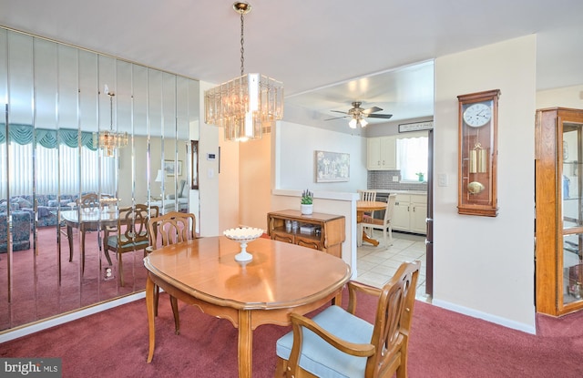 dining room with light colored carpet, baseboards, and ceiling fan with notable chandelier