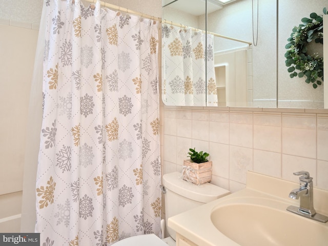 bathroom with toilet, vanity, tile walls, backsplash, and a shower with curtain