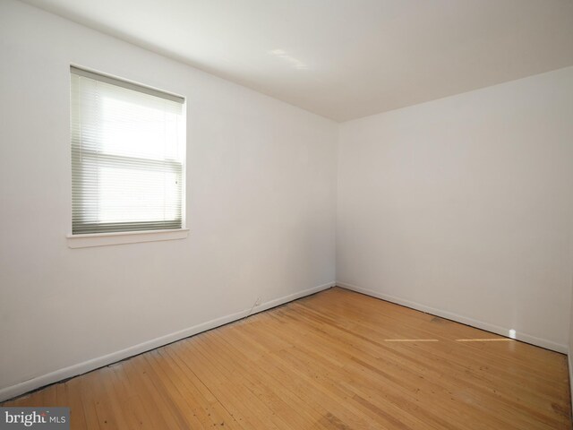 unfurnished room with light wood-type flooring and baseboards