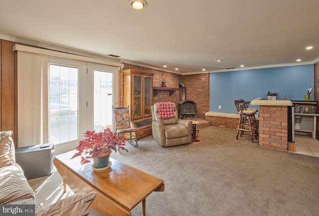 living room featuring recessed lighting, light colored carpet, visible vents, ornamental molding, and a wood stove