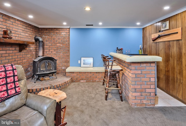 living area with a wood stove, a bar, crown molding, and light colored carpet