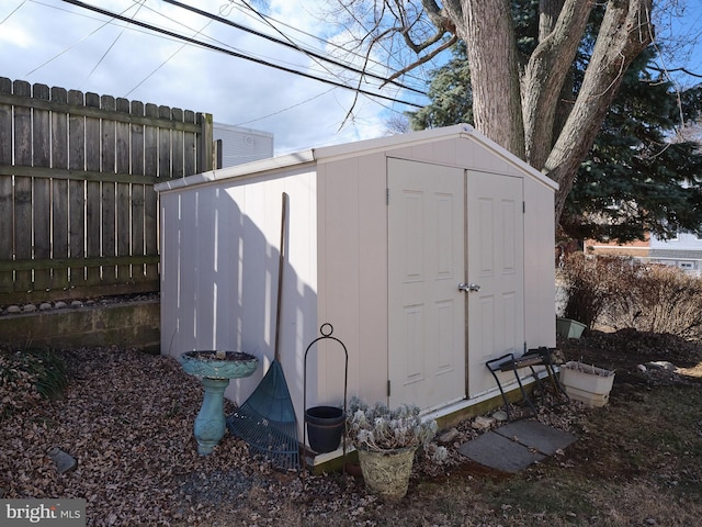 view of shed featuring fence