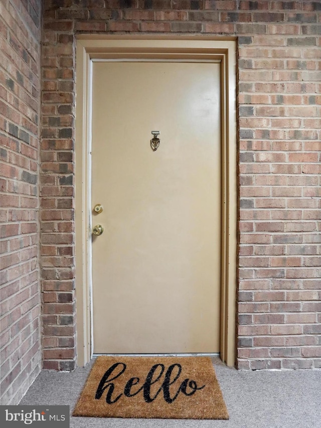 doorway to property featuring brick siding