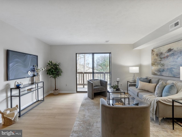 living area with light wood-type flooring, baseboards, and visible vents