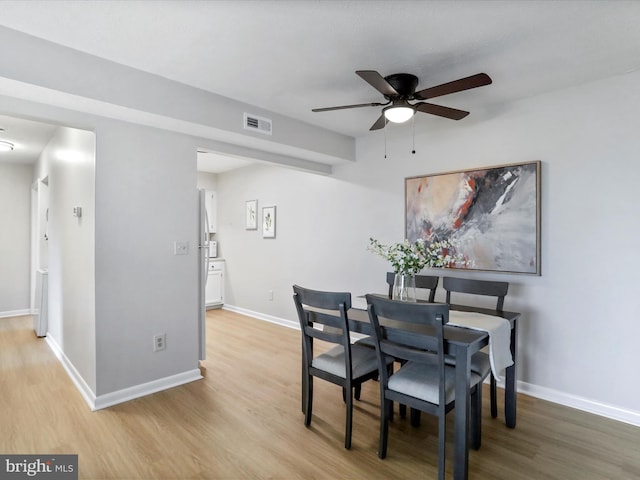 dining space with visible vents, light wood-style flooring, and baseboards