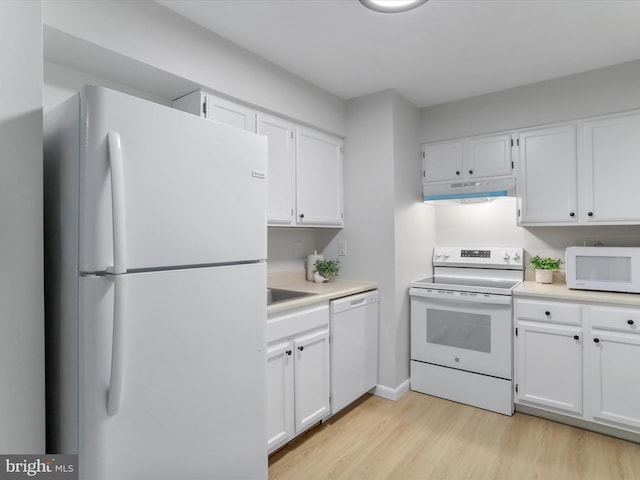 kitchen with white appliances, white cabinetry, and light countertops