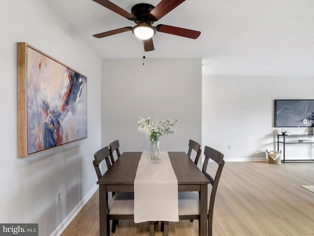 dining space with ceiling fan, baseboards, and wood finished floors