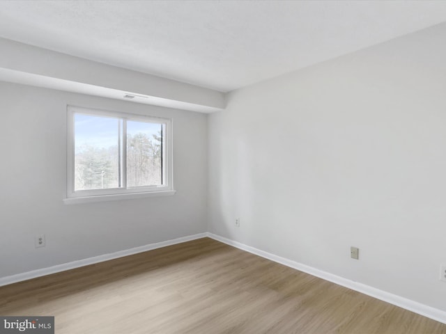 empty room featuring light wood finished floors and baseboards