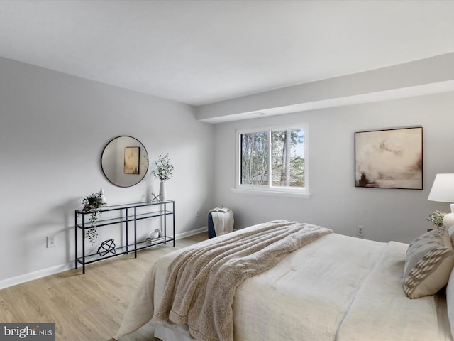 bedroom with light wood-style floors and baseboards