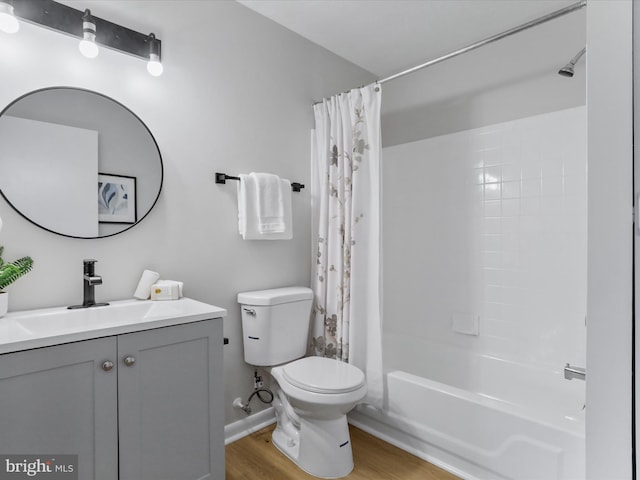 full bathroom with toilet, shower / tub combo, wood finished floors, vanity, and baseboards