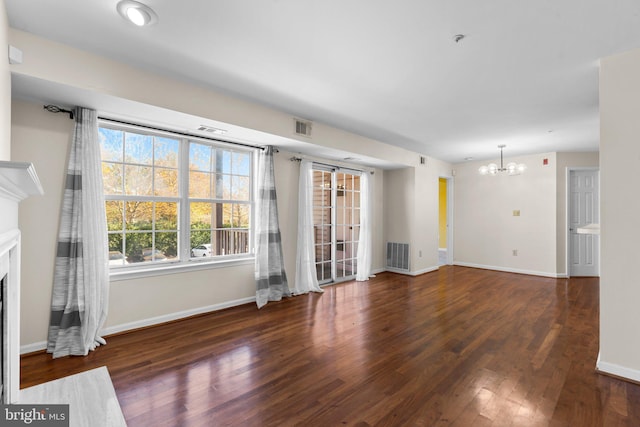 unfurnished living room featuring baseboards, a fireplace, visible vents, and dark wood finished floors