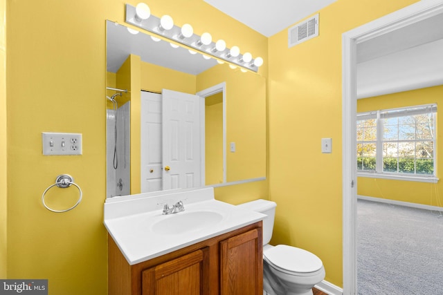 full bath with visible vents, toilet, vanity, baseboards, and walk in shower