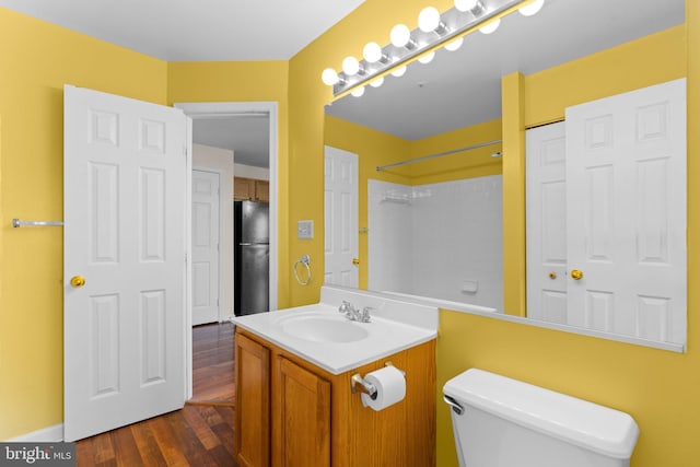 bathroom featuring toilet, wood finished floors, and vanity