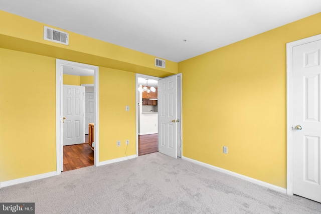 unfurnished bedroom featuring carpet floors, visible vents, and baseboards