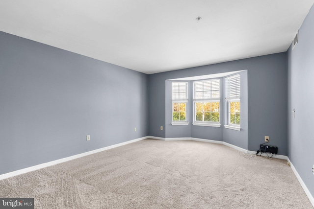 spare room with carpet and baseboards