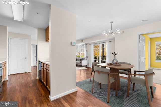 dining space featuring a chandelier, dark wood-style flooring, and plenty of natural light