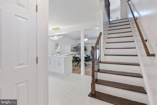 staircase featuring marble finish floor