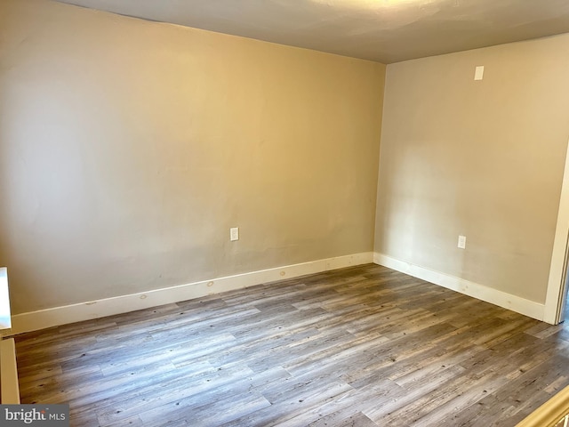 empty room featuring baseboards and wood finished floors