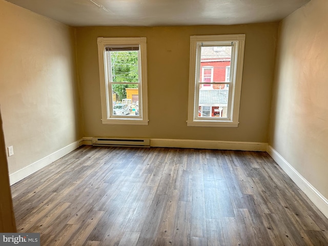 spare room featuring wood finished floors and baseboards