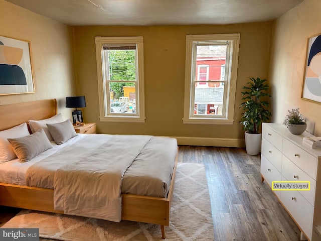 bedroom featuring wood finished floors and baseboards