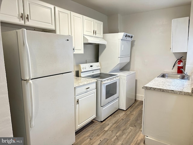 kitchen featuring white appliances, light countertops, under cabinet range hood, and white cabinets