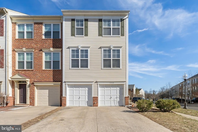 view of property with a garage, driveway, and brick siding