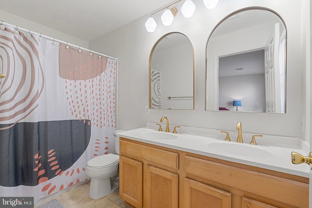 bathroom with double vanity, a sink, toilet, and tile patterned floors